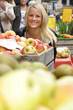 Junge Frau kauft Äpfel auf Markt