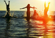 Silhouettes of people jumping in ocean