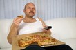 Overweight mature man sitting on the couch 